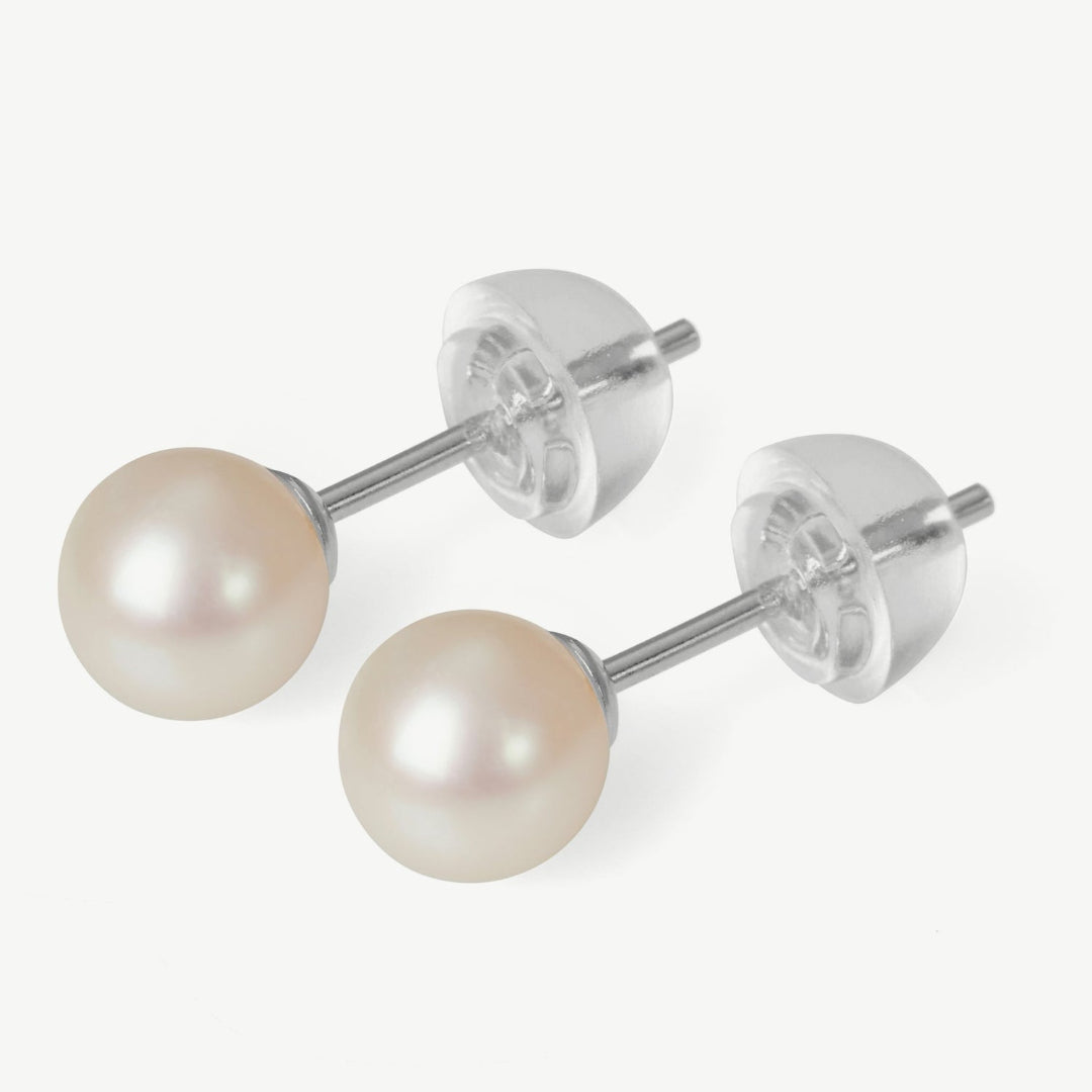 Pair of pearl stud earrings on a white background