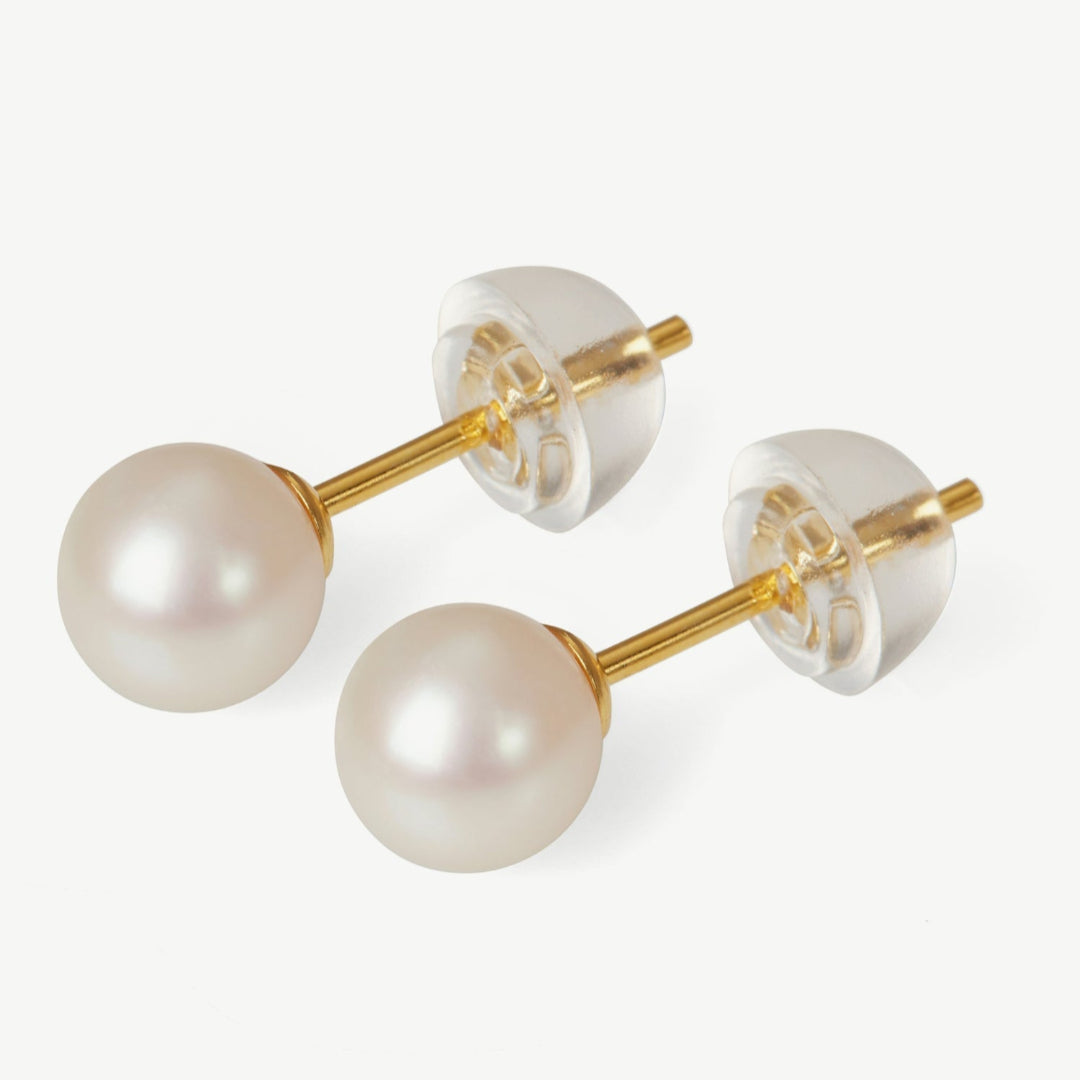 Pearl earrings with gold posts on a white background