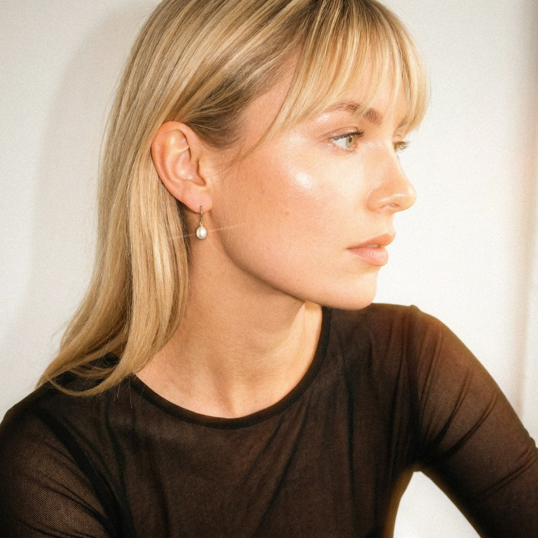 Woman wearing a brown top with a plain background