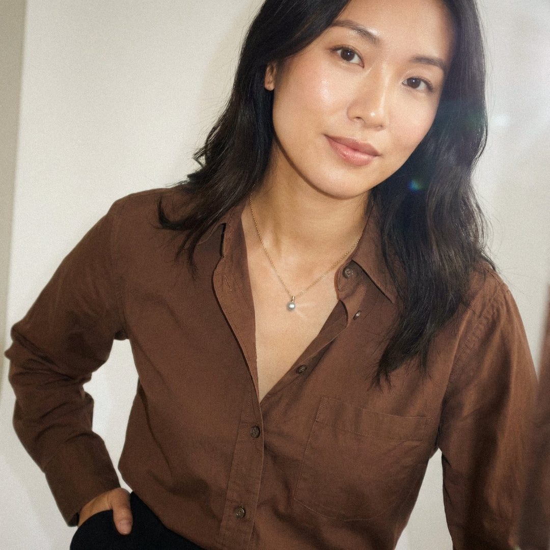 Woman wearing a brown shirt against a plain background