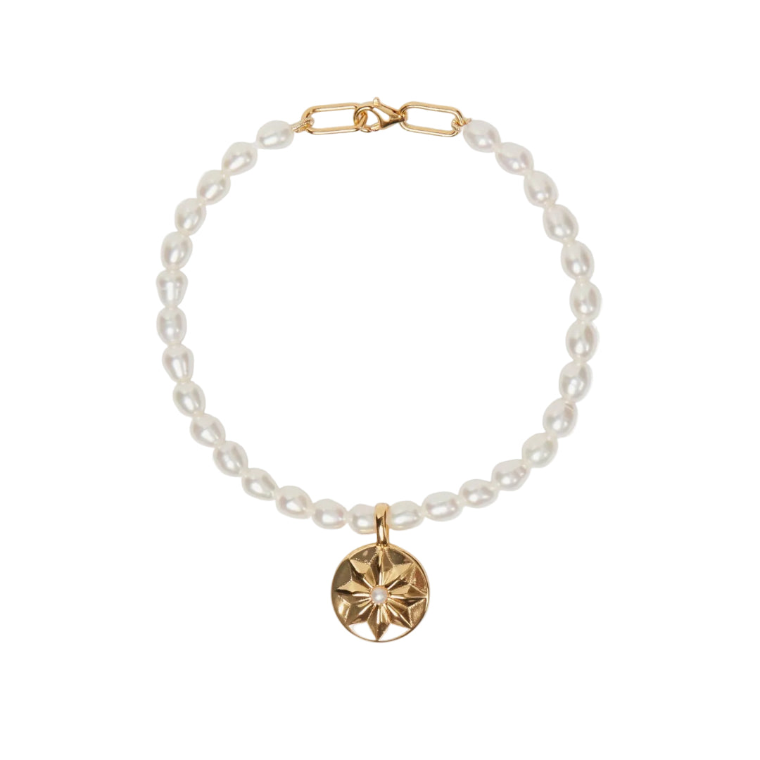 Pearl bracelet with a gold clasp and pendant on a white background