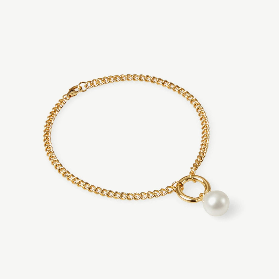 Gold bracelet with a pearl charm on a white background