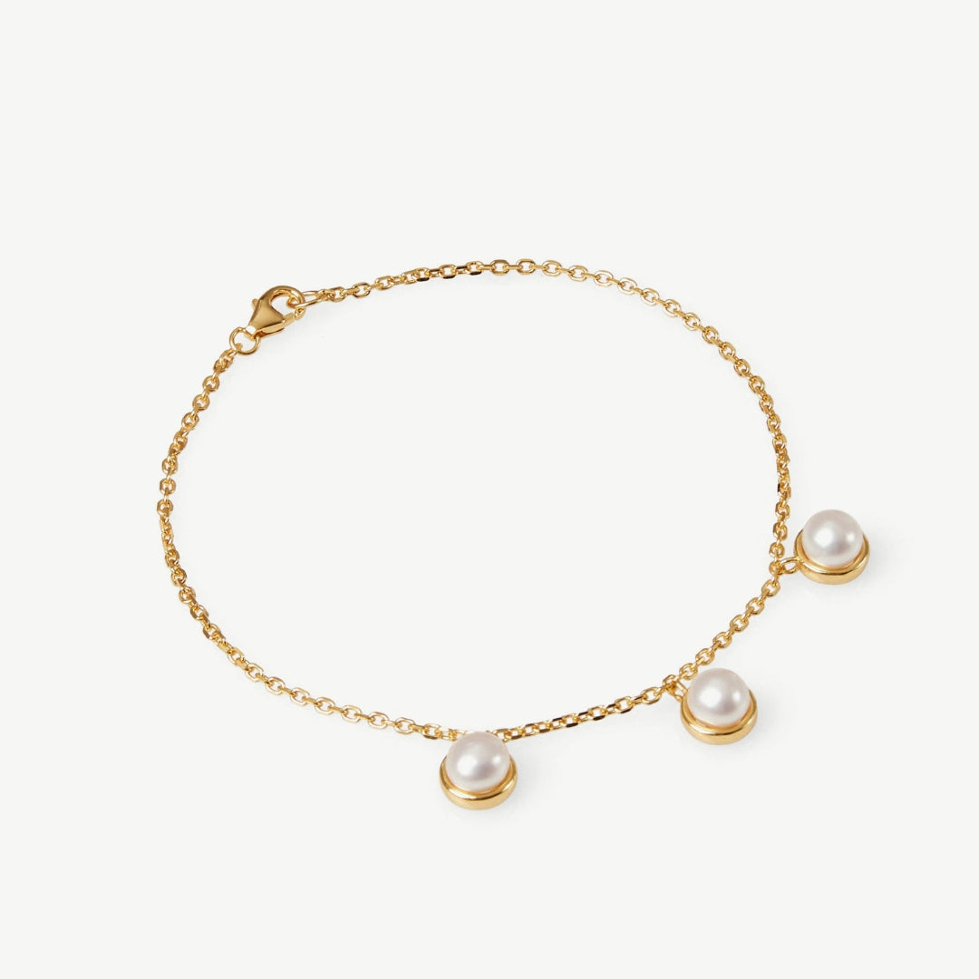 Gold bracelet with pearls on a white background