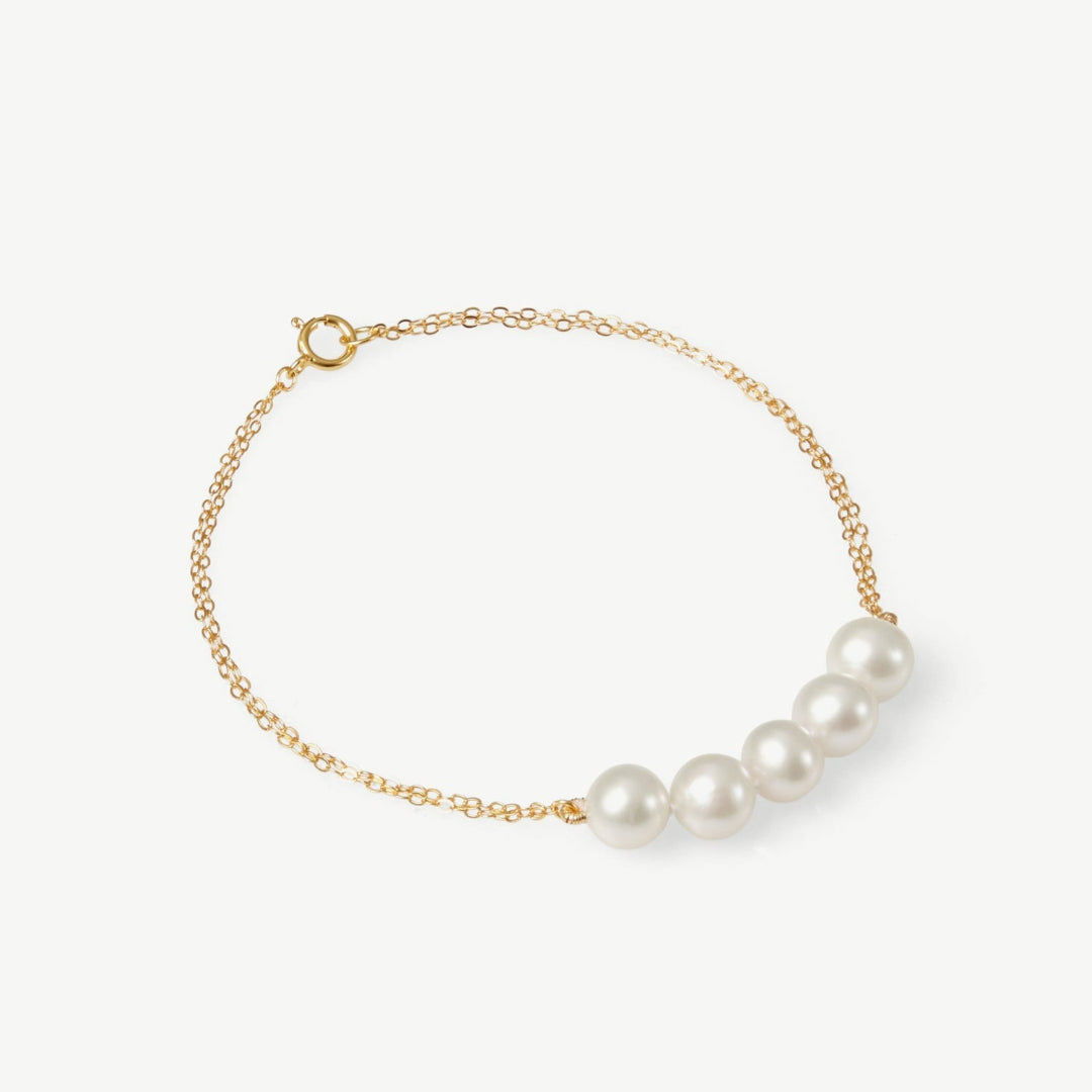 Pearl bracelet with gold chain on a white background