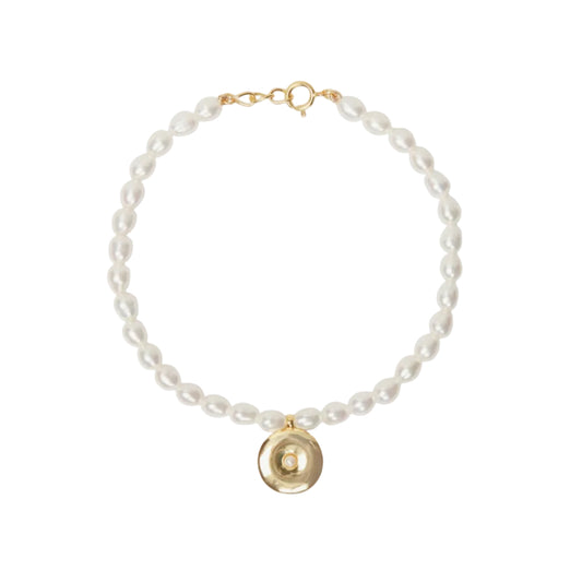 Pearl bracelet with a gold charm on a white background