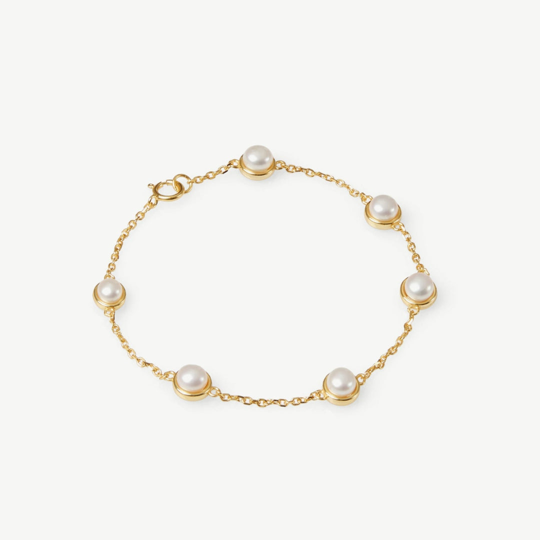 Gold bracelet with pearls on a white background