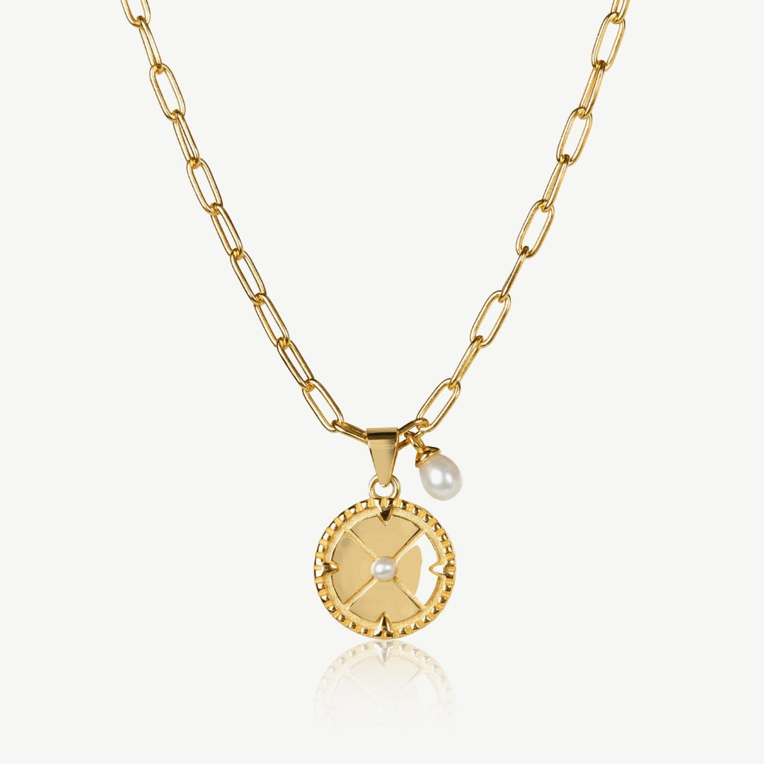 Gold necklace with a round pendant and pearl on a white background