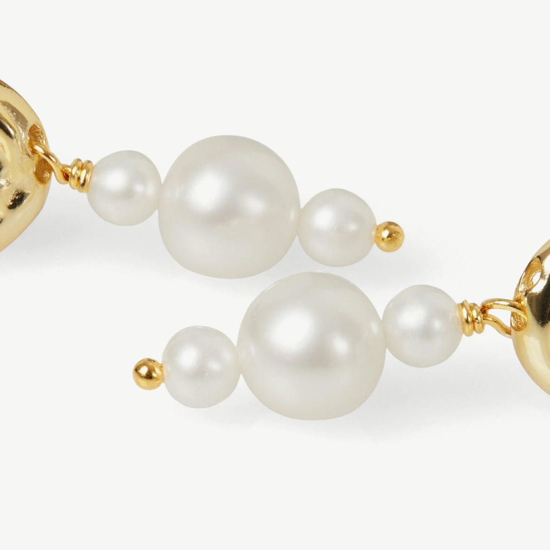 Pearl necklace with gold accents on a white background