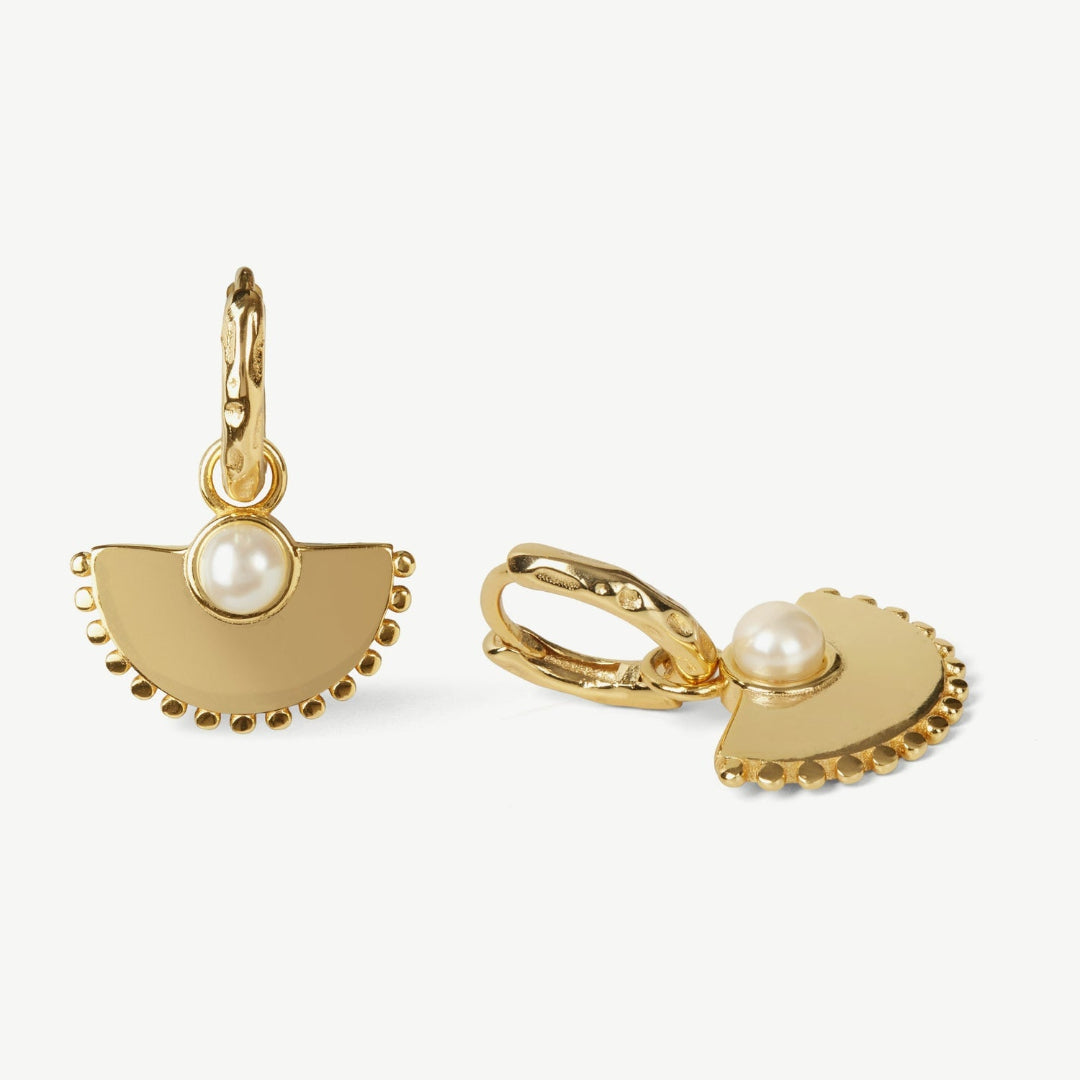 Gold earrings with pearl accents on a white background