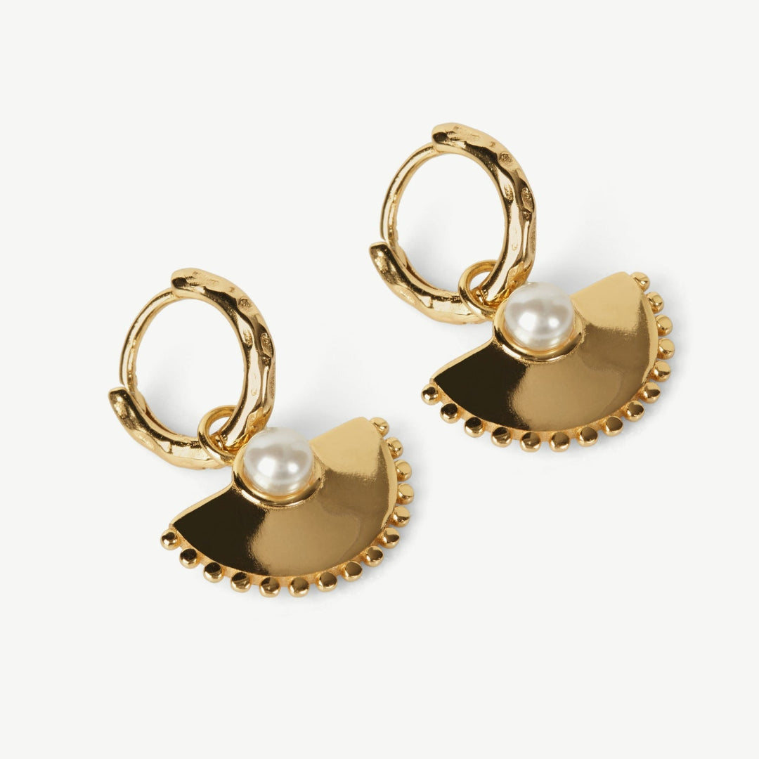 Gold hoop earrings with half-circle pendants and pearls on a white background