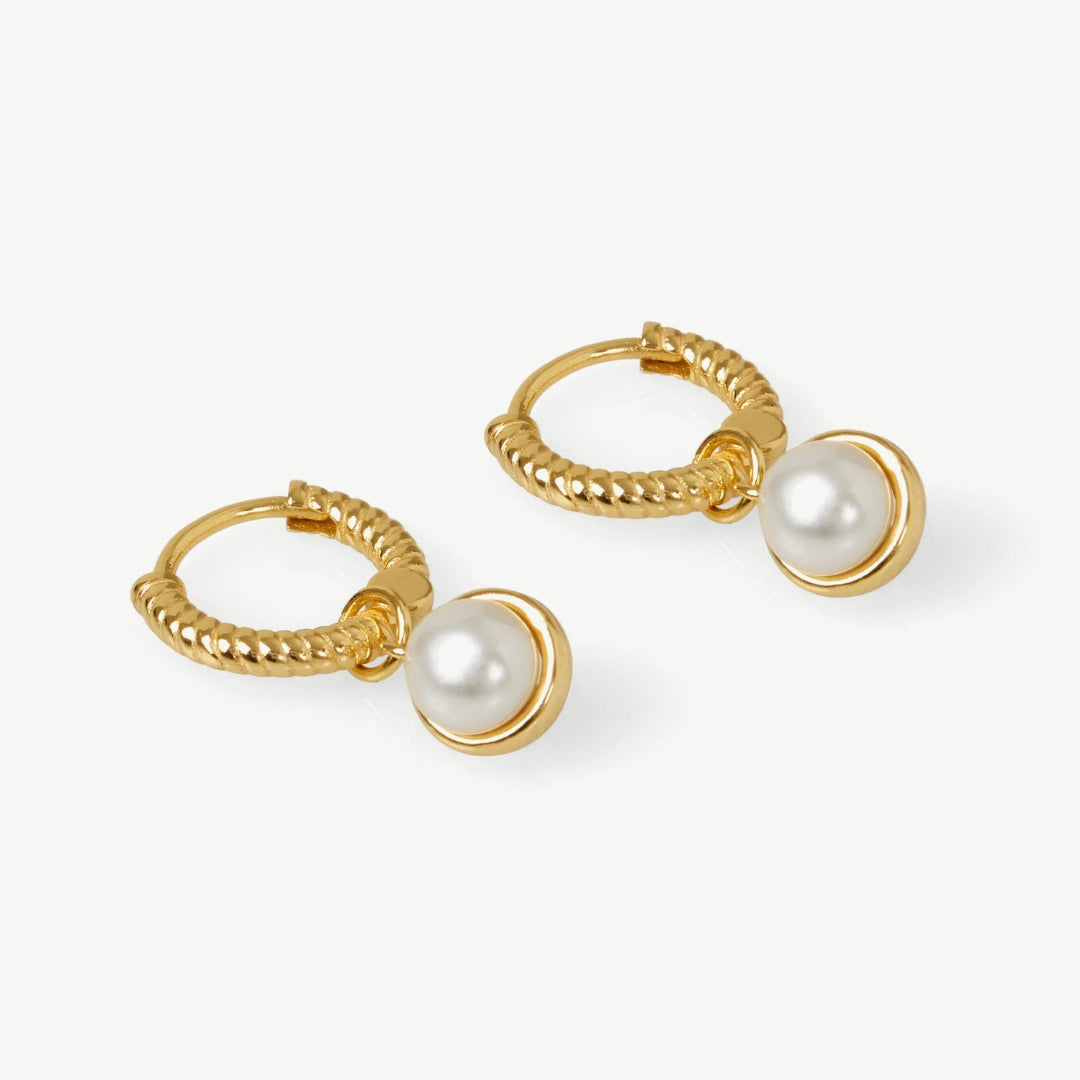 Gold hoop earrings with pearl drops on a white background