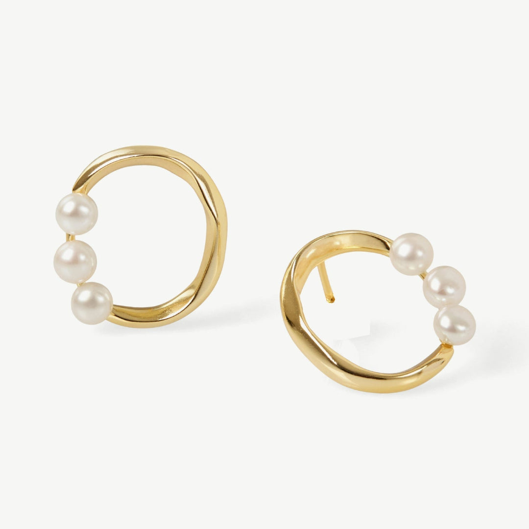 Gold hoop earrings with pearls on a white background