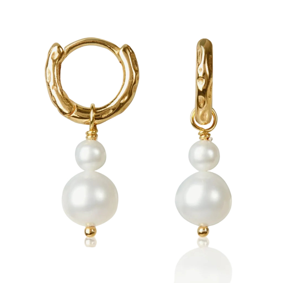 Gold hoop earrings with white pearl drops on a white background