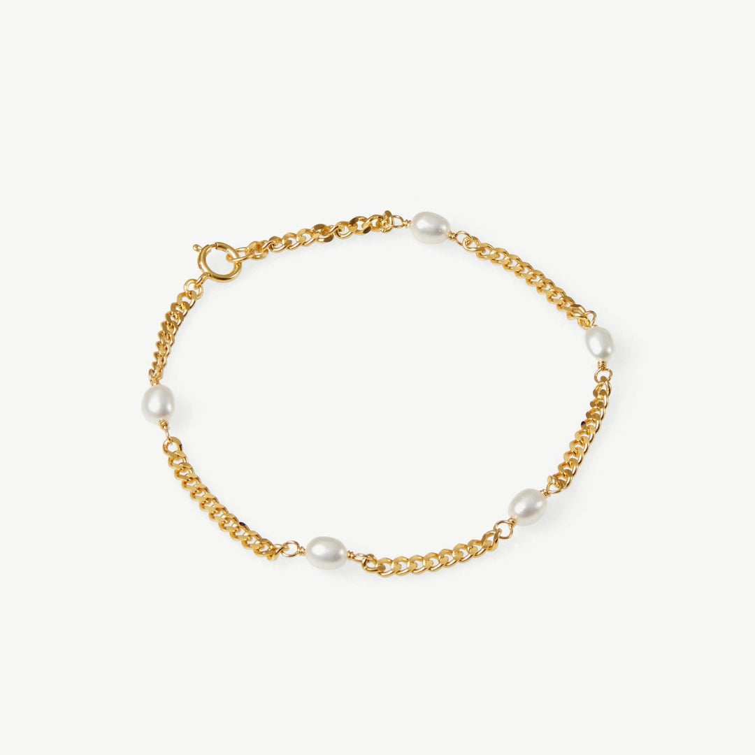 Gold chain bracelet with pearls on a white background