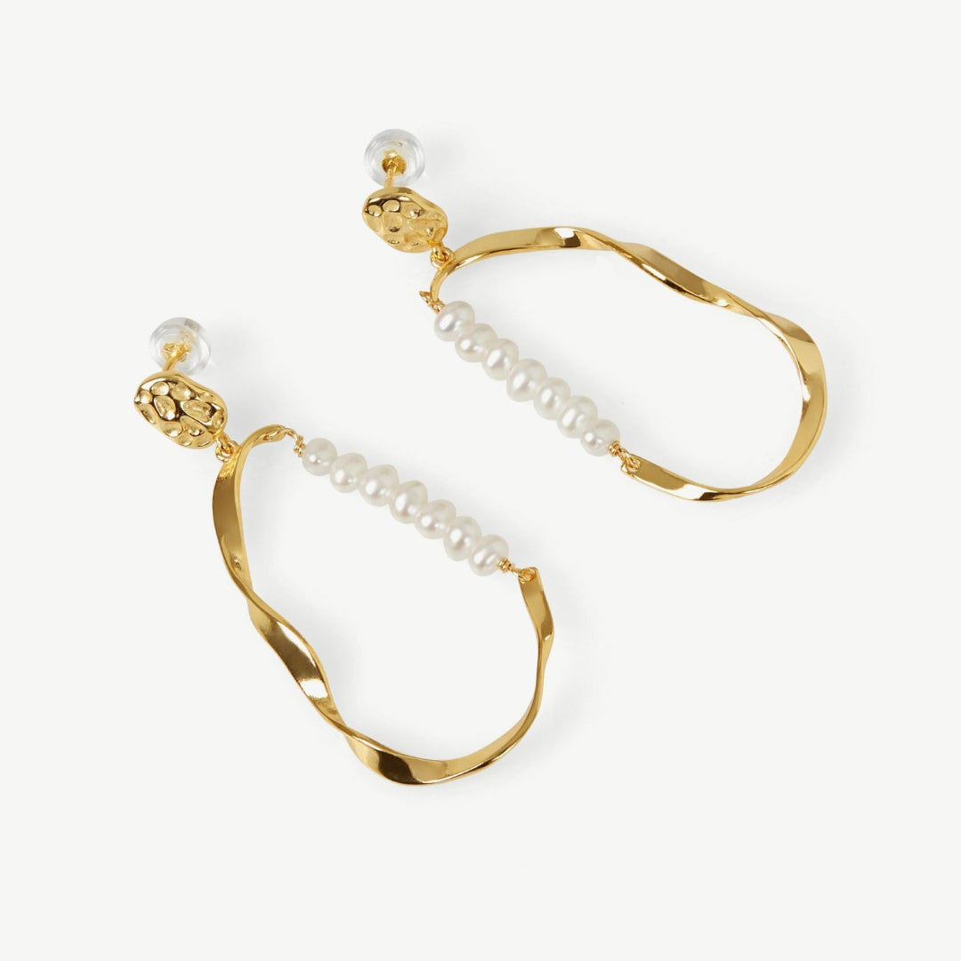 Gold hoop earrings with pearl accents on a white background