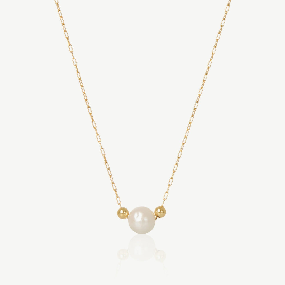 Gold necklace with a pearl pendant on a white background