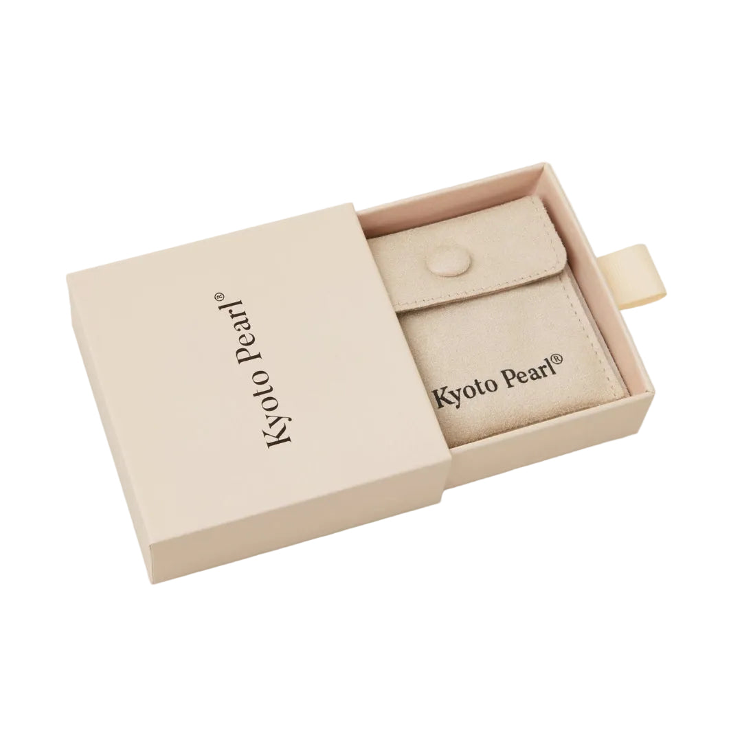 Beige jewelry pouch in a 'Kyoto Pearl' branded box on a white background